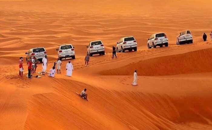 a group of people in white robes standing in a desert