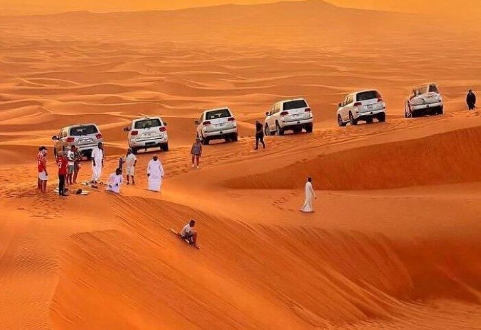 a group of people in white robes standing in a desert