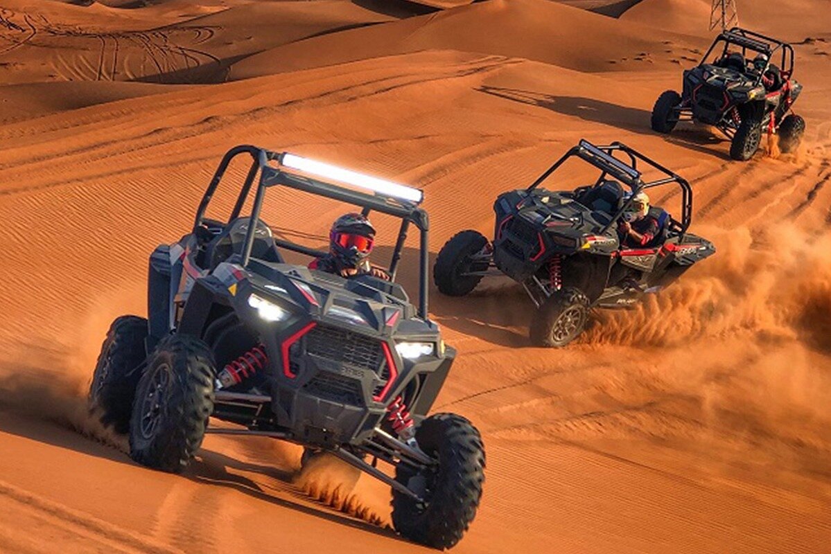 a group of people driving off road vehicles in the desert