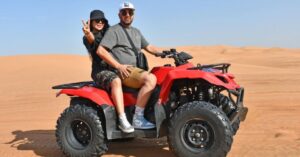 What to wear in Dubai desert safari – comfortable outfit for men and women with hat, sunglasses, and breathable clothing in sand dunes